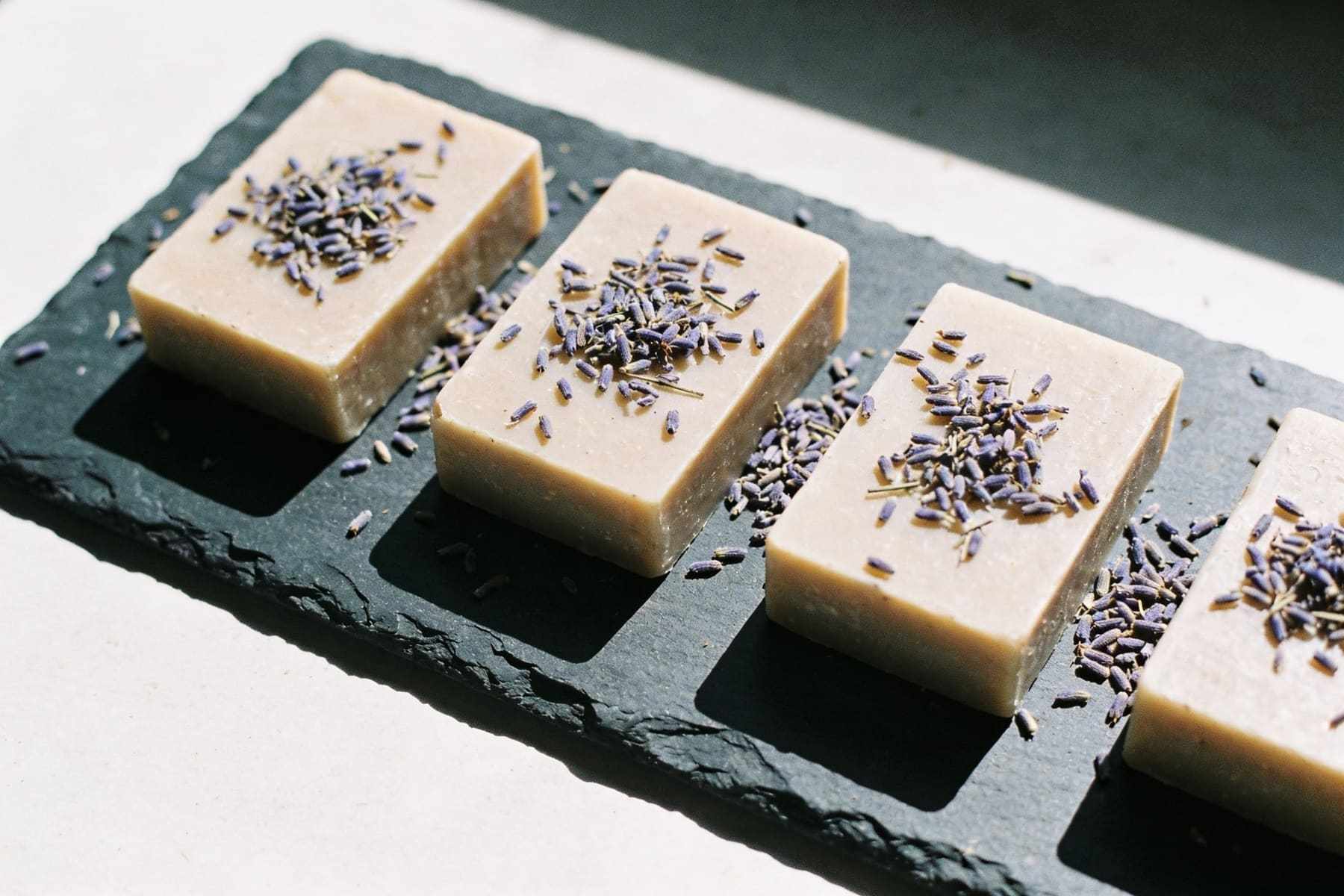 Lavender soap bars on a slate board seen from above.